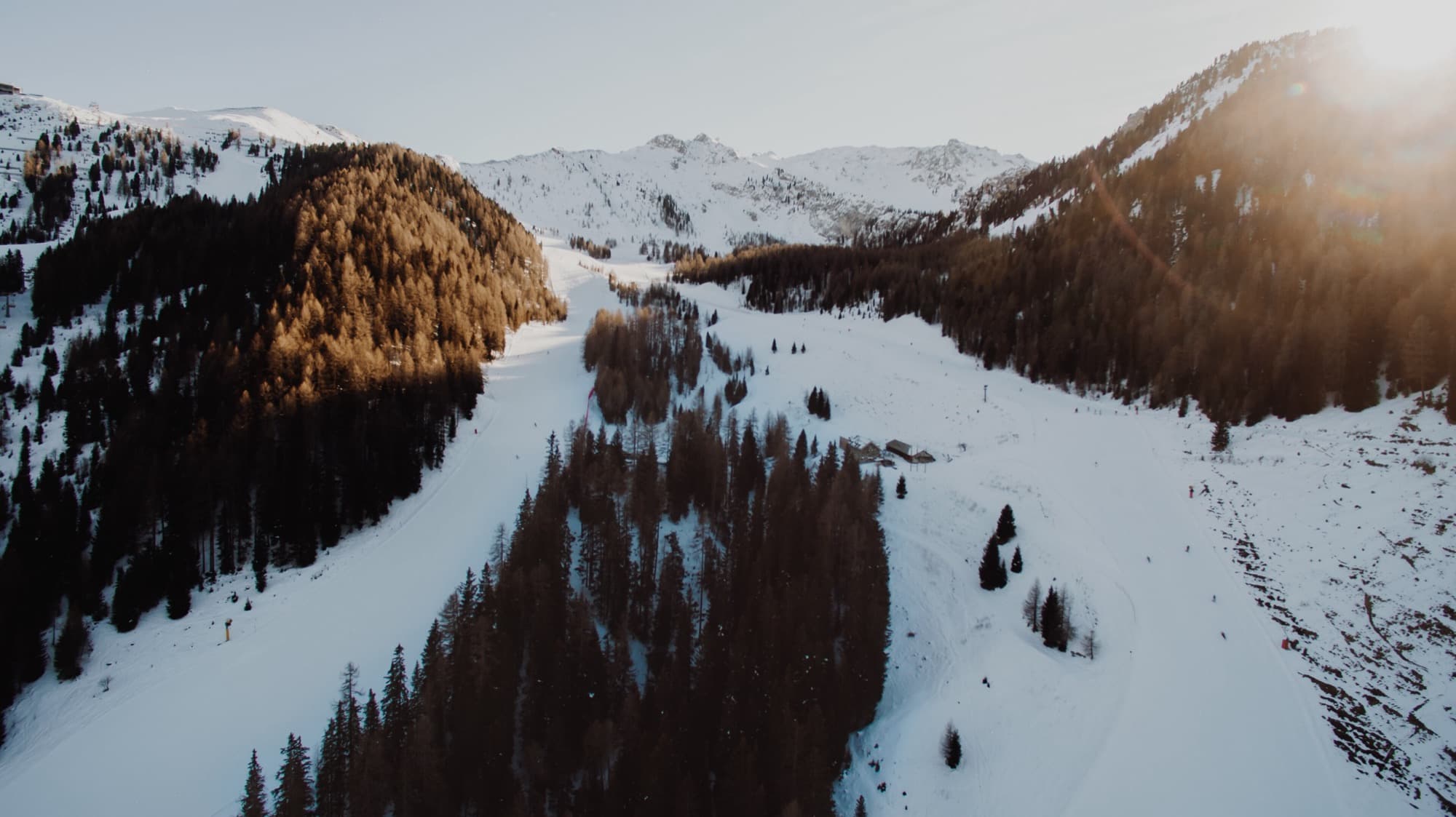 Tree-lined pistes running down an Italian valley